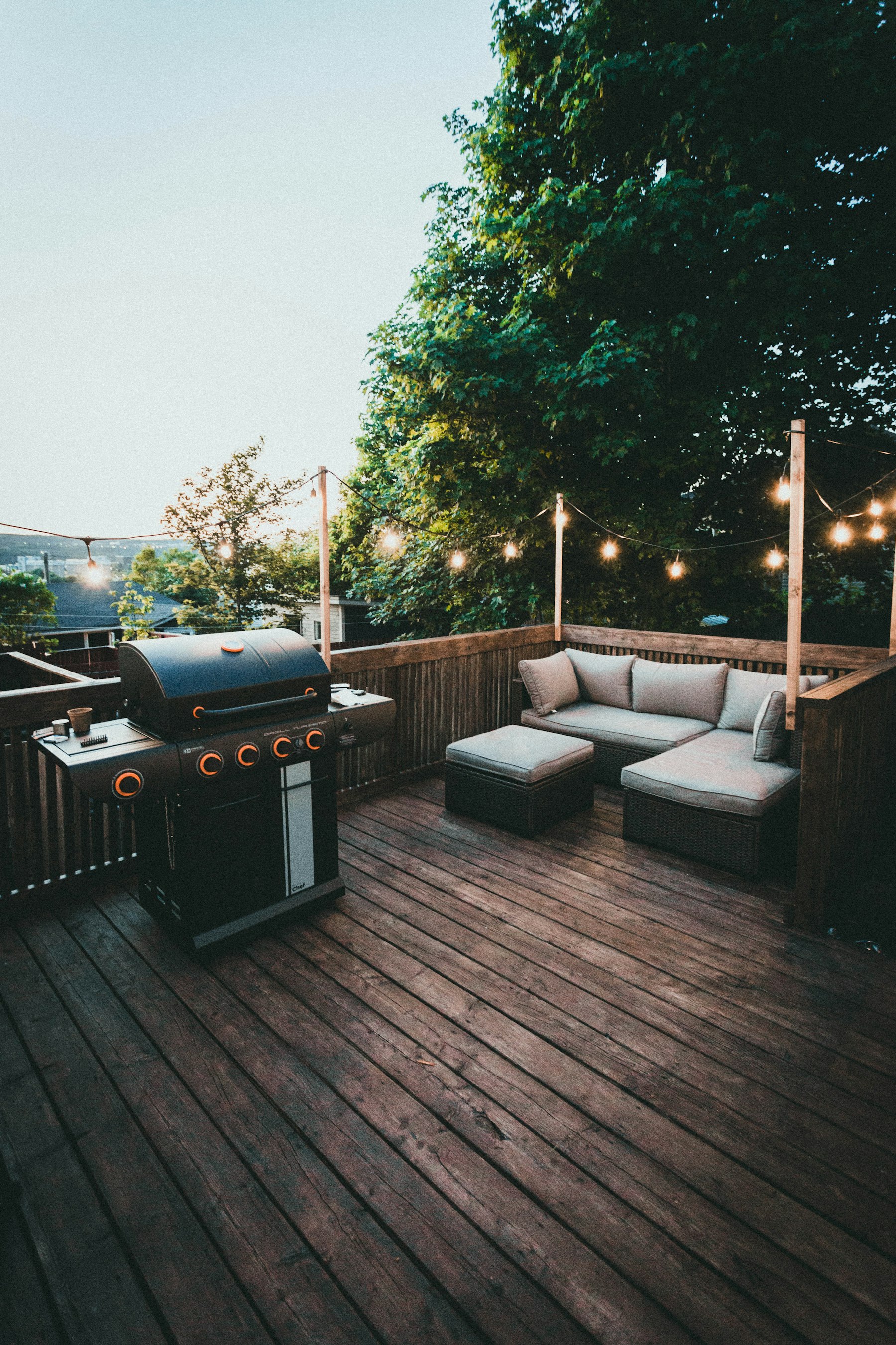 Moderne Holzterrasse an einem Wohnhaus mit gepflegtem Garten